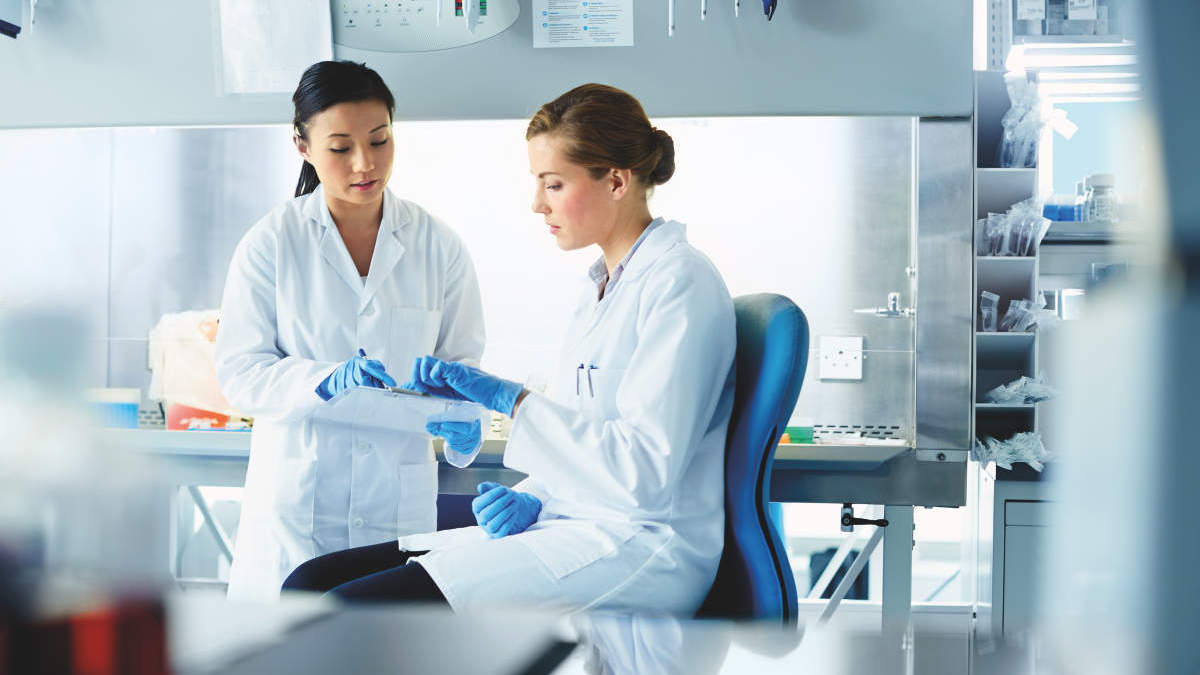 Female scientists discussing research in modern laboratory